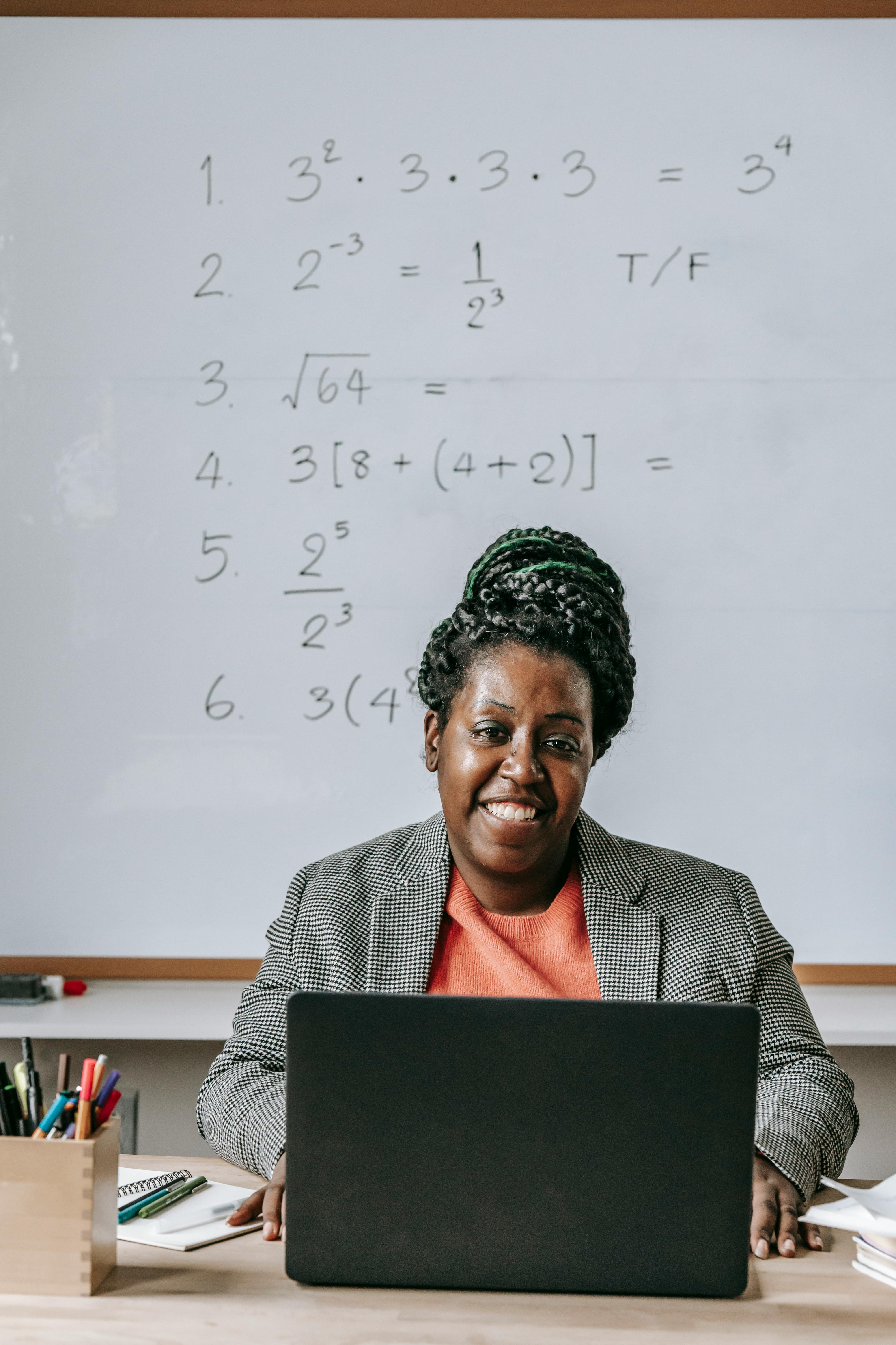 Teacher using computer in classroom with secure school systems